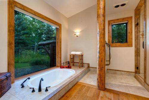 a bathroom with a tub and a large window at Abode at Sweetwater in Wilson