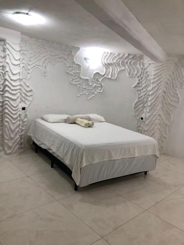 a bedroom with a bed in a room with a patterned wall at Flor de Lótus Privilege in Japaratinga