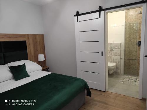 a bedroom with a bed and a bathroom with a shower at Agroturystyka U Sadzy in Krajno Pierwsze