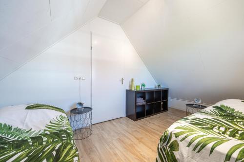 a attic bedroom with two beds and a television at Holiday Home Zeewolde in Zeewolde