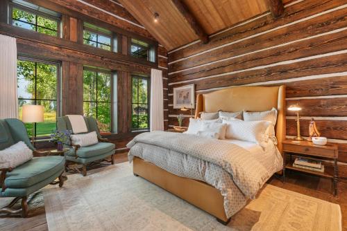 a bedroom with a bed and a chair and windows at Abode at Teton Game in Wilson