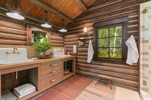 a bathroom in a log cabin with a sink and a window at Abode at Teton Game in Wilson