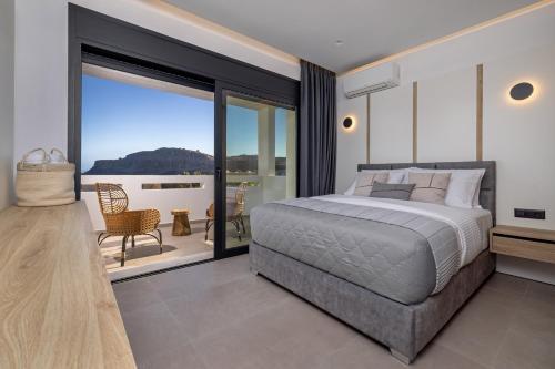 a bedroom with a large bed and a balcony at Luxury Villa Amani Retreat in Lindos