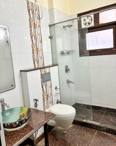 a bathroom with a toilet and a glass shower at Sparra Homes in Gurgaon