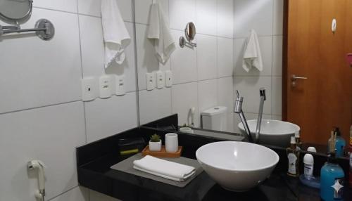 a bathroom with a sink and a large mirror at Iloa Studio Alagoas conforto e encantamento in Barra de São Miguel