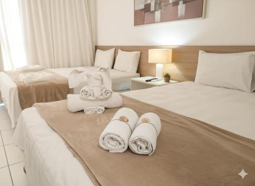 a hotel room with two beds with towels on them at Iloa Studio Alagoas conforto e encantamento in Barra de São Miguel