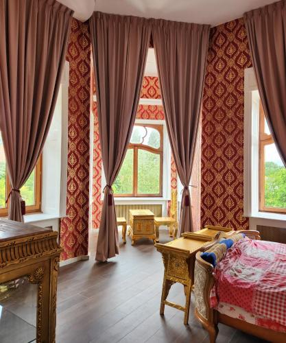 a bedroom with red curtains and a bed and a table at Kasteel Rosmeulen in Mall