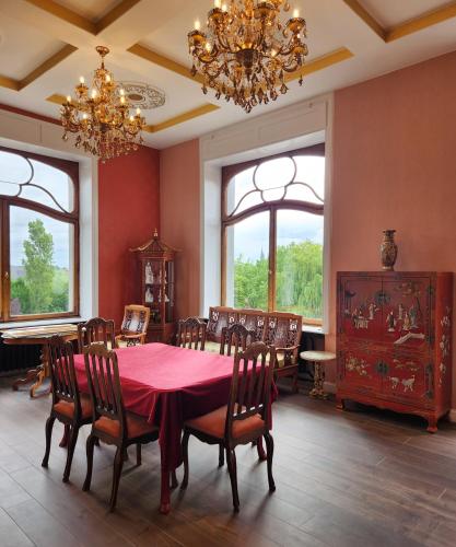 a dining room with a table and chairs and a chandelier at Kasteel Rosmeulen in Mall