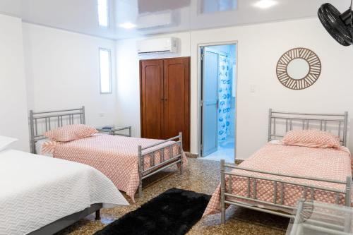 a room with two beds and a door into a room at HOTEL GANADERO in La Dorada