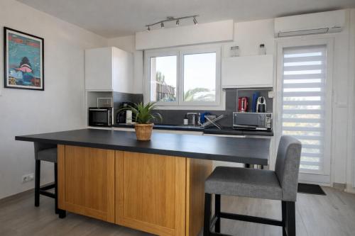 a kitchen with a large island with a black counter top at Etrave in Toulon