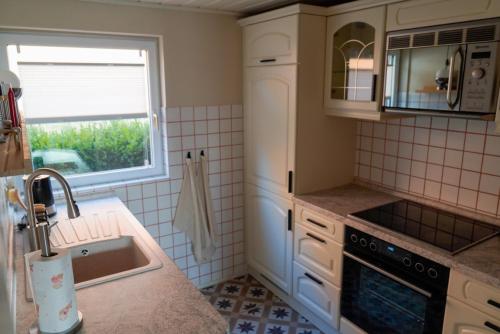 a small kitchen with a sink and a window at Bungalow Friedrich in Thale