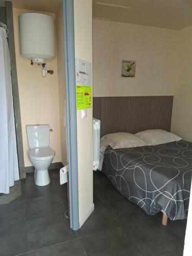 a hotel room with a bed and a toilet at Hotel Motel Limoux in Limoux