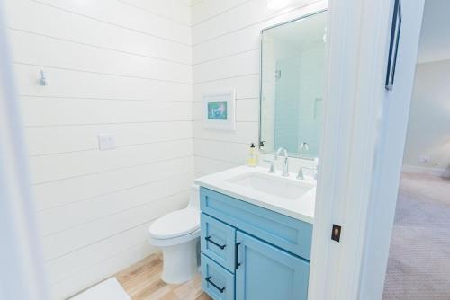 a bathroom with a toilet and a sink and a mirror at Breezy Beachside Views! Heated Pool & Pickleball! in Holmes Beach