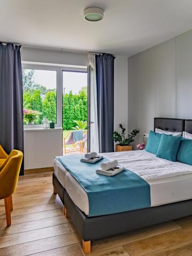 ein Schlafzimmer mit einem großen Bett und einem großen Fenster in der Unterkunft Villa7 Balaton in Alsóörs
