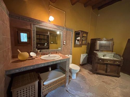 a bathroom with a sink and a toilet and a television at Molino Santiago in Torre de las Arcas