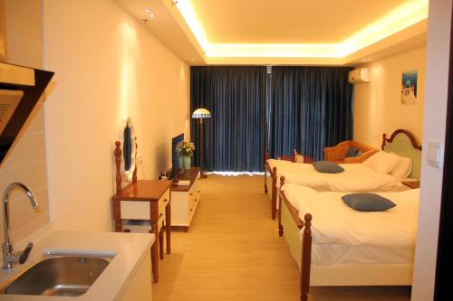 a hospital room with four beds and a sink at Coast-Inn Hailing Island in Yangjiang