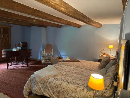 a bedroom with a bed and a desk and a piano at Molino Santiago in Torre de las Arcas