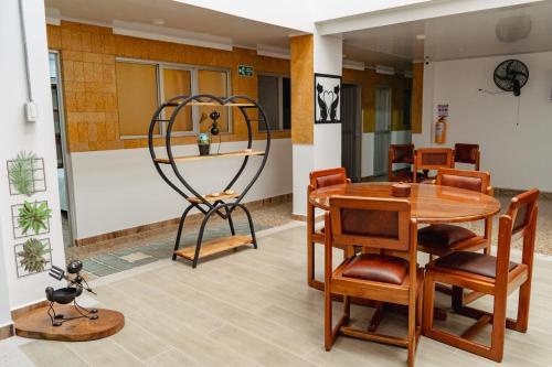 a dining room with a table and chairs and a metal sculpture at HOTEL GANADERO in La Dorada