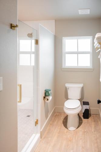 a bathroom with a white toilet and a shower at Gloria Inn - Unit 8 in Waco