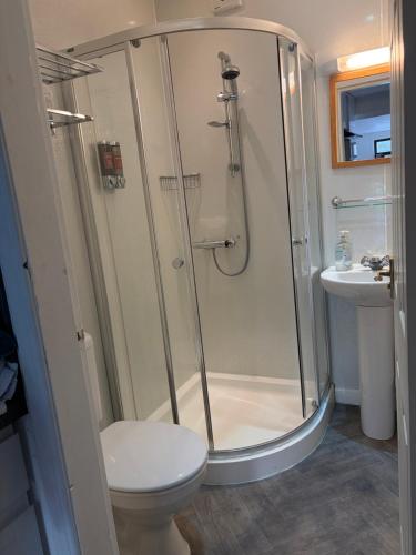 a bathroom with a shower and a toilet and a sink at The Glebe in Fort William