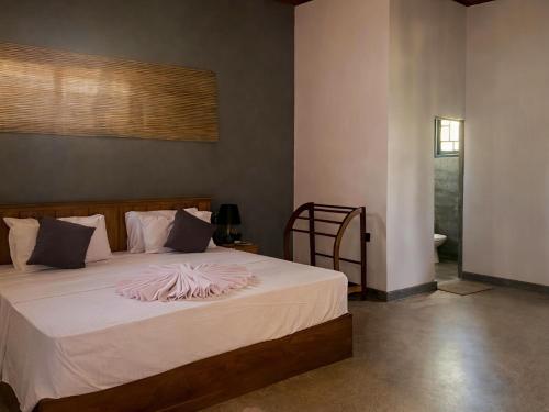 a bedroom with a bed with a pink blanket on it at Turtle Moon Lodge in Rekawa
