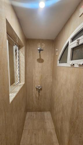 a bathroom with a toilet and a window at بيان للاجنحة الفندقية - سوق الخوير in Muscat