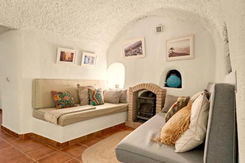 a living room with a couch and a fireplace at LAS DUNAS Caves - Olivo in Benamaurel
