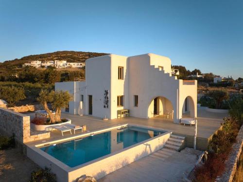 a villa with a swimming pool in front of a house at OceanLight Horizon - luxury Villa with private pool in Nea Cryssi Akti