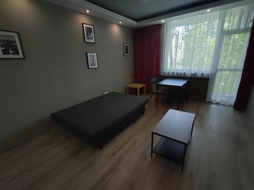 a bedroom with a bed and a table in it at Városközpont Tata in Tata