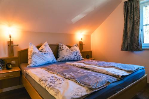 a bedroom with a bed with blue sheets and pillows at Ferienwohnung Kahlseneck in Fischerndorf