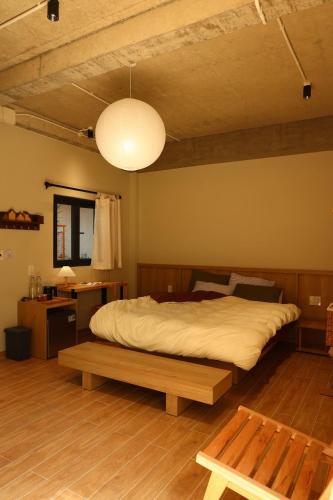 a bedroom with a large bed and a table at Hale Homestay in Ấp Thanh Sơn (1)