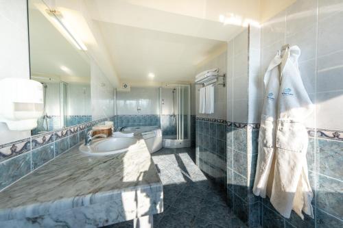 a bathroom with a tub and a sink and a mirror at Spa Hotel Dvoretsa in Velingrad