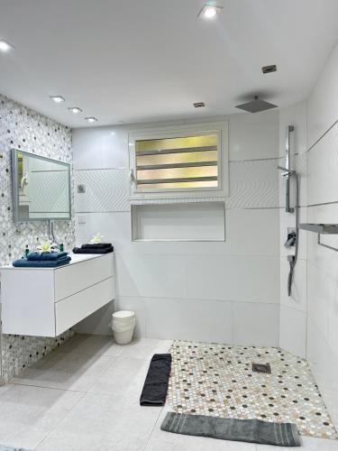 a white bathroom with a sink and a toilet at Résidence Adam et Eve in Orient Bay