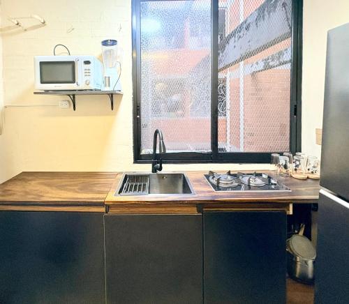 a kitchen with a sink and a microwave at Departamento tranquilo Huatulco in Santa Cruz Huatulco