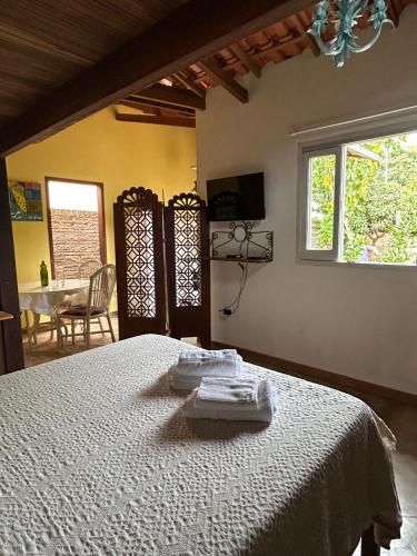 a bedroom with a bed with towels on it at Casinha da Mila in Piatã