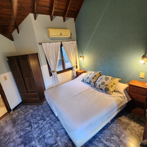 a bedroom with a white bed and a window at Merlo Trail Lodge in Merlo