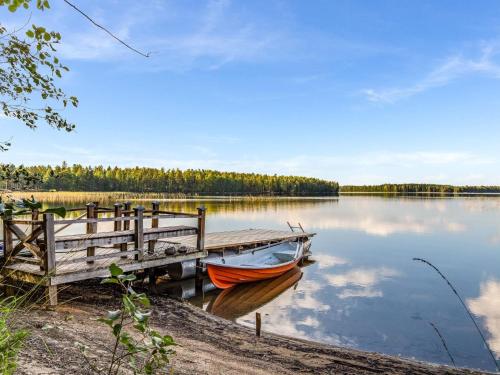a boat is docked at a dock on a lake at Holiday Home Villa populus by Interhome in Pertunmaa