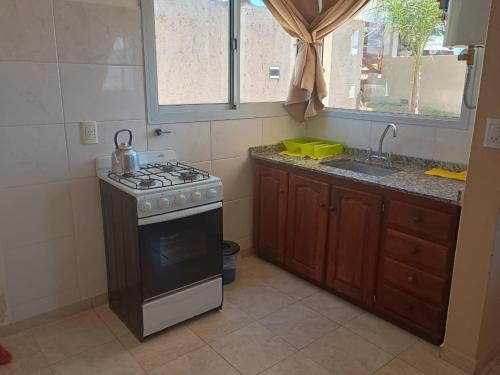 a kitchen with a stove and a sink at Vista del Lago in Villa Carlos Paz