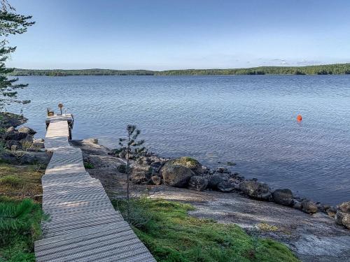 two people standing on a wooden bridge over a lake at Holiday Home Klippan by Interhome in Tuuhonen