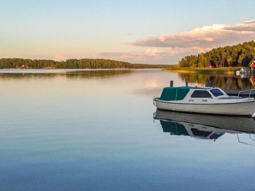 a boat sitting in the water on a lake at Holiday Home Jarsala by Interhome in Töfsala
