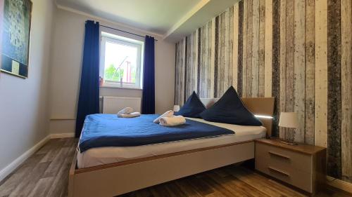 a bedroom with a bed with blue sheets and a window at 08 Heuwiese - Hof Wiesengrund in Parchtitz