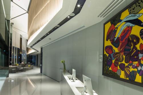 a large colorful painting on the wall in a hallway at Modena by Fraser Bangkok in Bangkok