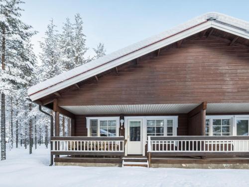 a log cabin in the snow with snow covered trees at Holiday Home Albatrossi by Interhome in Levi