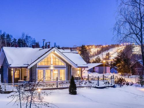 a house in the snow with lights on at Holiday Home Akavilla 2 by Interhome in Jämsä