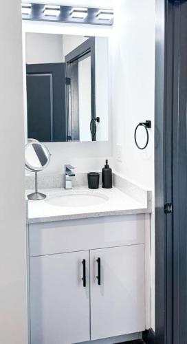 a bathroom with a white sink and a mirror at Stylish Studio Apt-Outside NYC in West New York