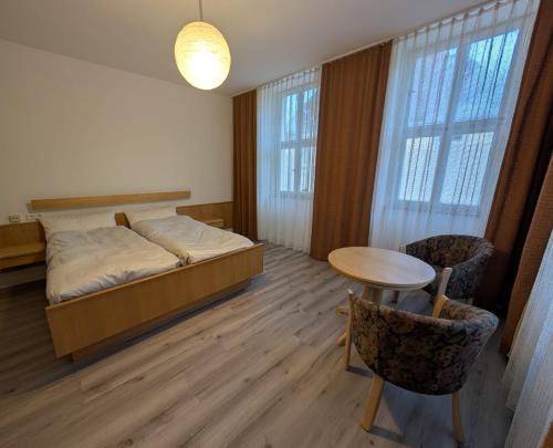 a bedroom with a bed and a table and chairs at Serviced Rooms ''Krone'' in Creglingen