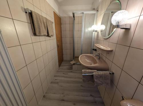a bathroom with a sink and a mirror at Serviced Rooms ''Krone'' in Creglingen