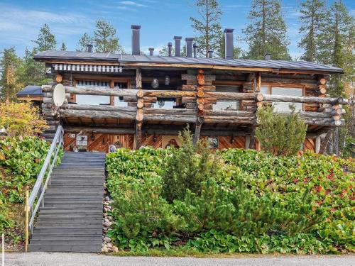 a log cabin with a staircase leading up to it at Holiday Home Sallanhelmi e2 by Interhome in Salla