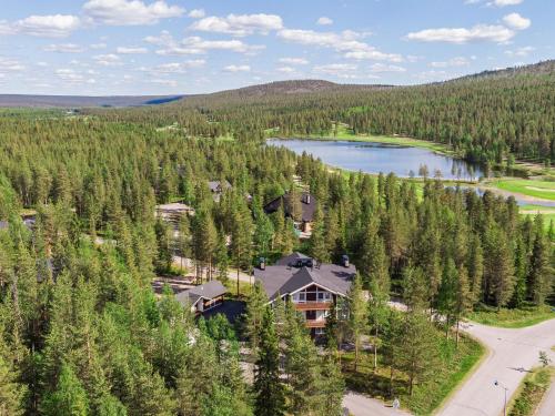 an aerial view of a house in a forest next to a lake at Holiday Home Golfväylä 3b - golf-osakkeen käyttöoikeus by Interhome in Levi