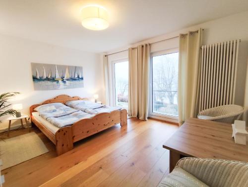 a bedroom with a wooden bed and a large window at Ferienhaus Iris in Radolfzell am Bodensee